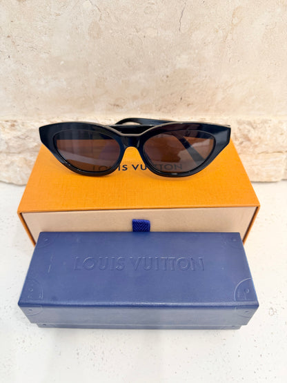 Louis Vuitton sunglasses on a matching orange and blue box with a textured beige background