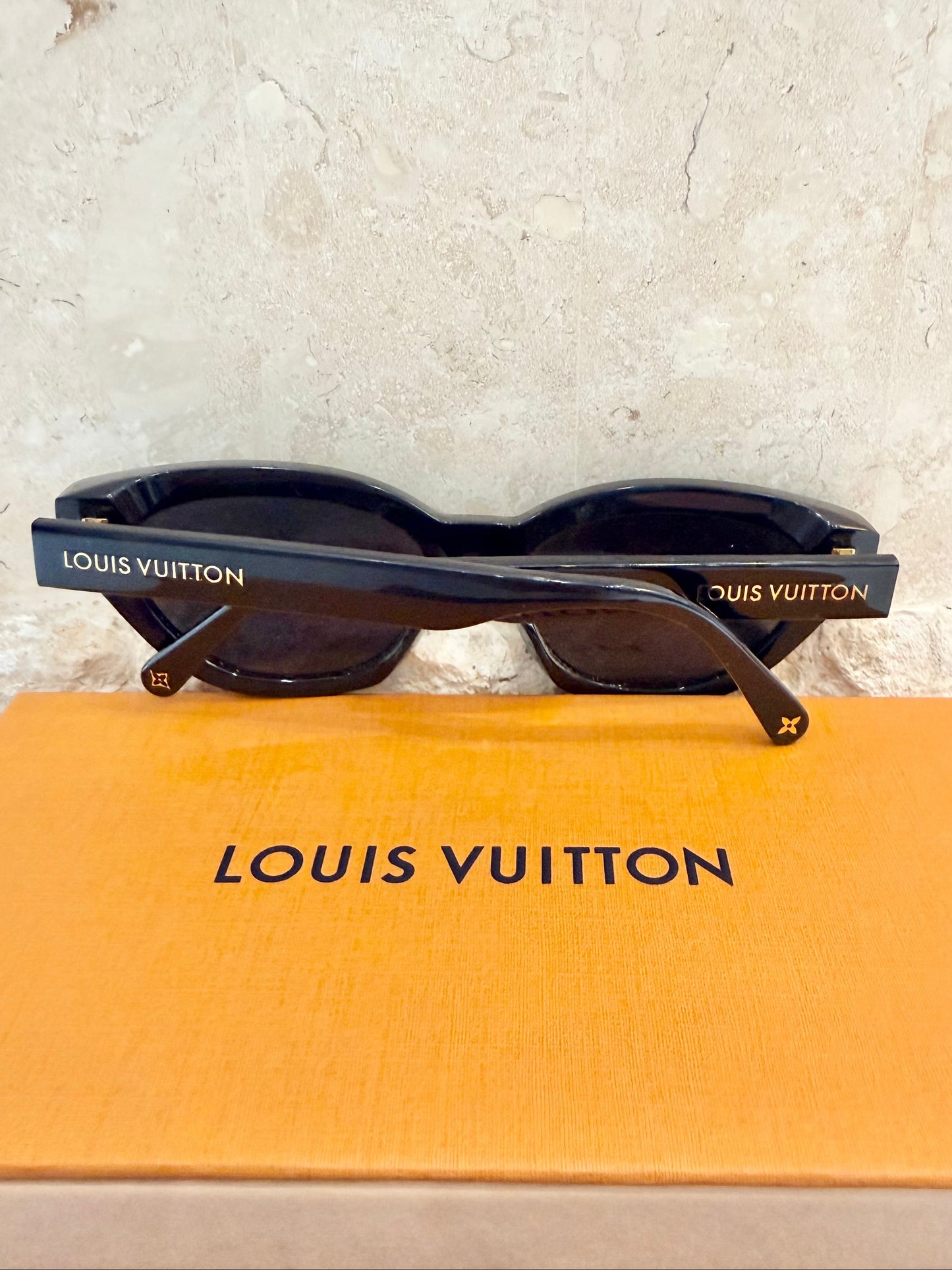 Louis Vuitton sunglasses on a Louis Vuitton box with a light gray background