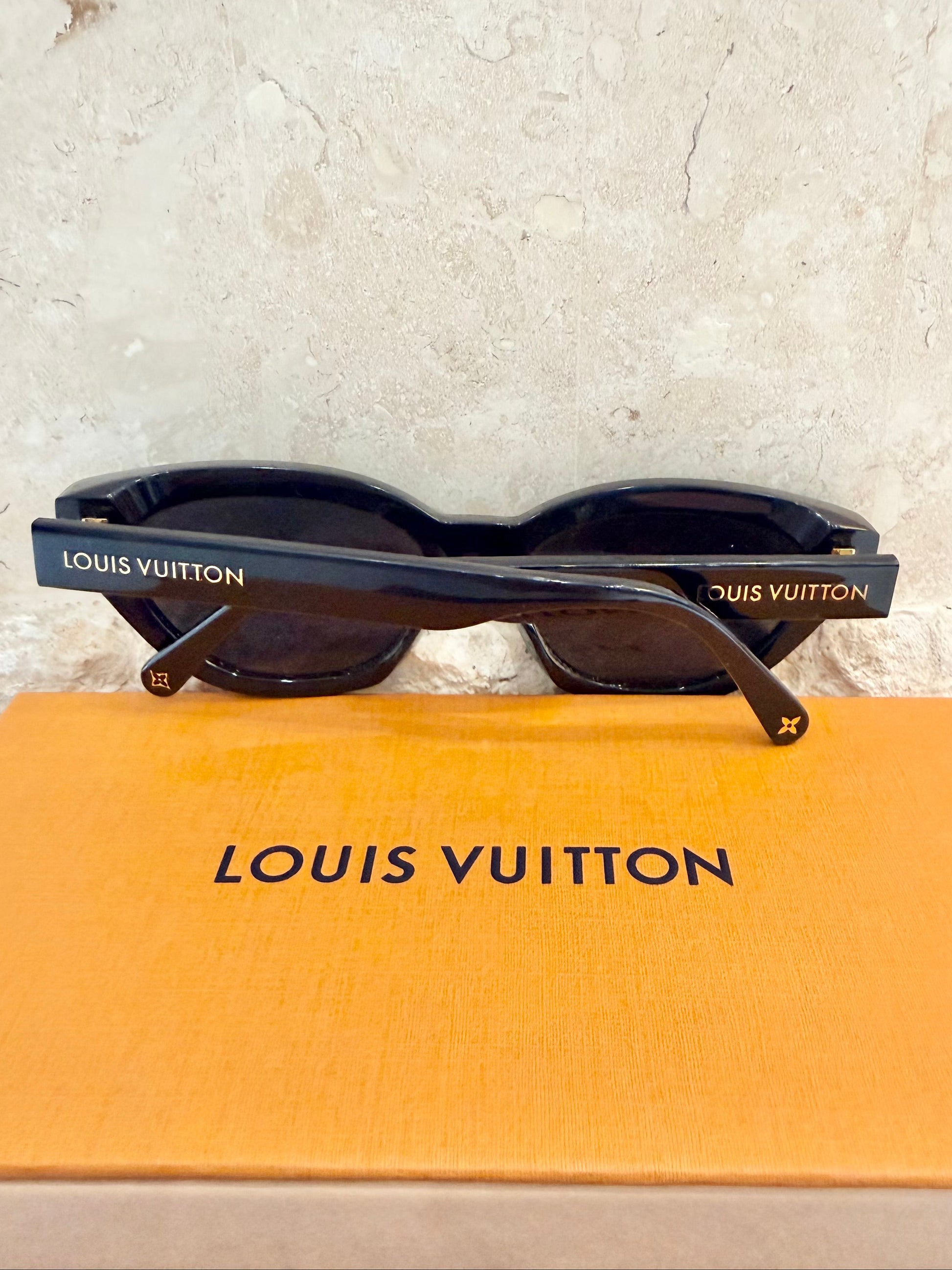 Louis Vuitton sunglasses on a Louis Vuitton box with a light gray background